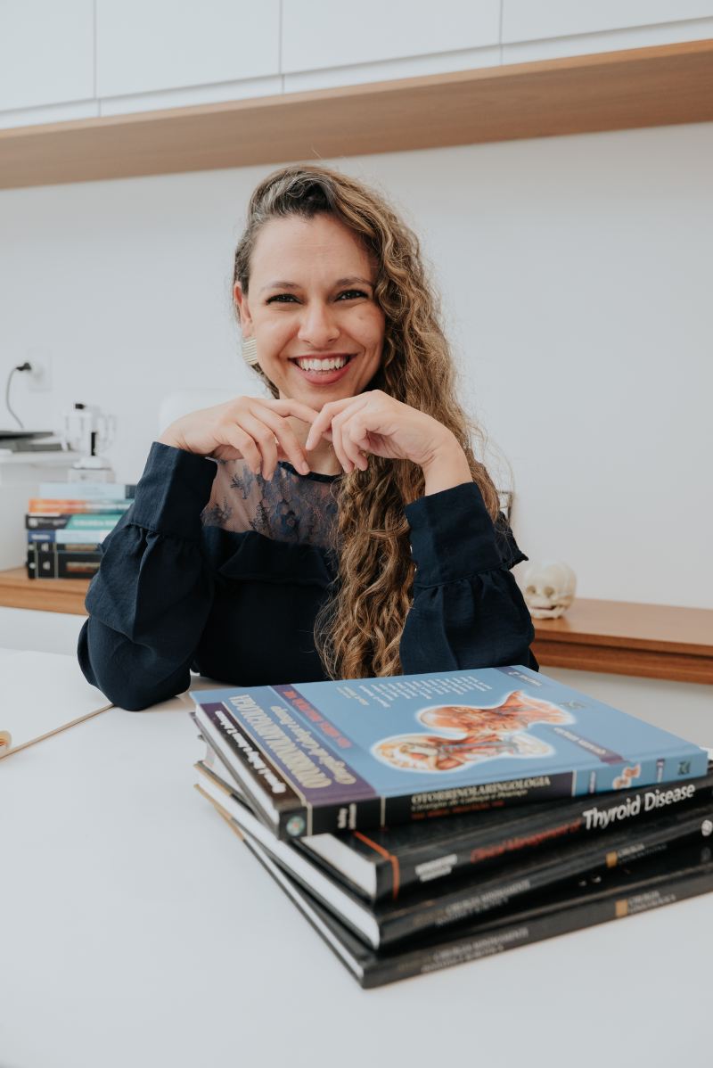 Dra. Cristiane com livros de Medicina